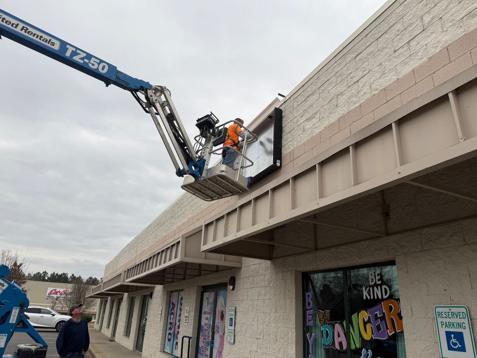 Crane installing a large monument sign on site